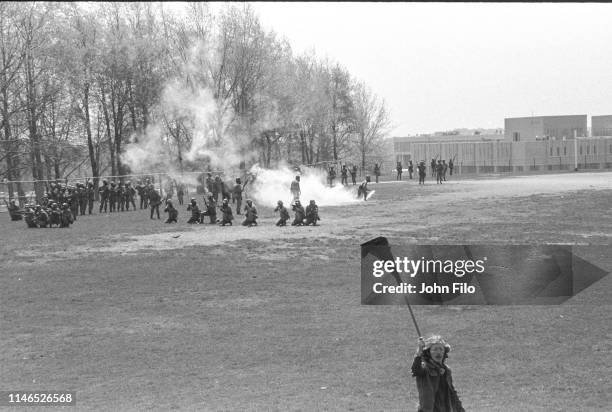 Kent State University student Alan Canfora waves a black flag as Ohio Army National Guardsmen kneel and aim their rifles on the university's practice...