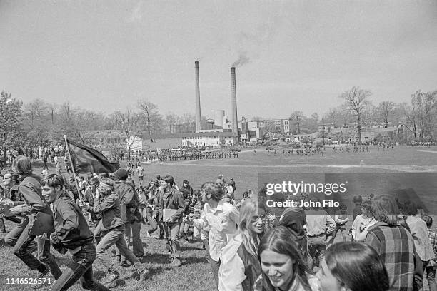 View from Blanket Hill of Kent State University students as they begin to turn and run from armed Ohio National Guardsmen, who advance across the...