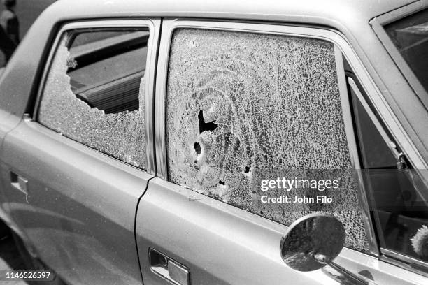 View of the broken windows of a parked car caused by bullets after the Ohio National Guard opened fire on antiwar protesters at Kent State...