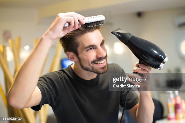 parrucchiere maschio che si pettina i capelli - hair dryer foto e immagini stock