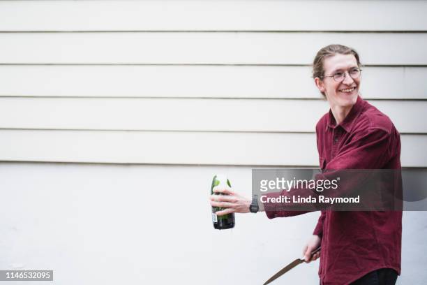 young man opening a champagne bottle - broken champagne flute stock pictures, royalty-free photos & images