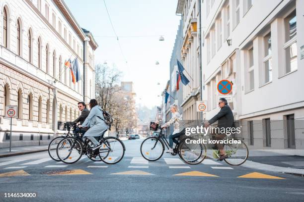 groep van vier senioren rijden een fiets in de stad - slovenië stockfoto's en -beelden