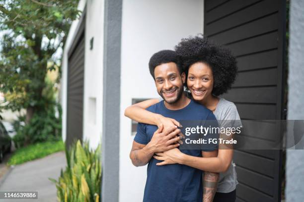 lovely couple smiling outdoors in front of house - in front of stock pictures, royalty-free photos & images