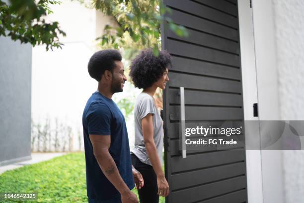par som står vid deras dörr, väntar på någon - man opening door woman bildbanksfoton och bilder