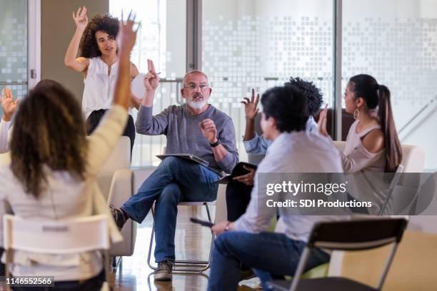 group of neighbors take a vote during hoa meeting - vizinho imagens e fotografias de stock