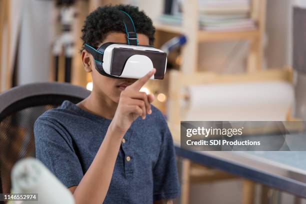 teenage boy plays virtual reality game - virtual reality kids stock pictures, royalty-free photos & images