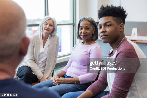 multi-ethnic group listens intently to unrecognizable man - listening intently stock pictures, royalty-free photos & images
