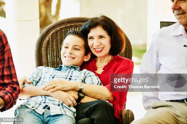 Smiling grandmother sitting with grandson during family celebration