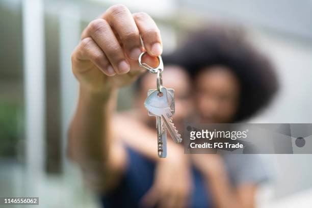 jong paar voor een huis, die sleutels van hun nieuwe huishouden - homeowner stockfoto's en -beelden