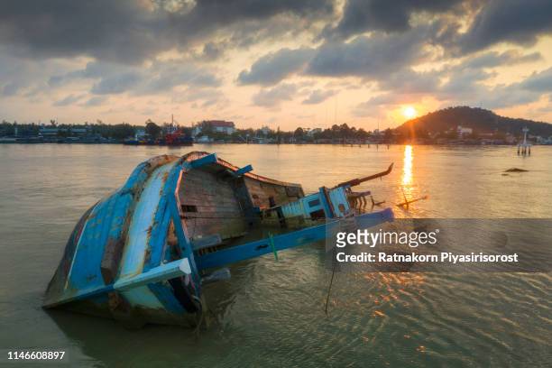 shipwreck or wrecked fishing ship in the sunrise scene ,thailand - capsizing stockfoto's en -beelden