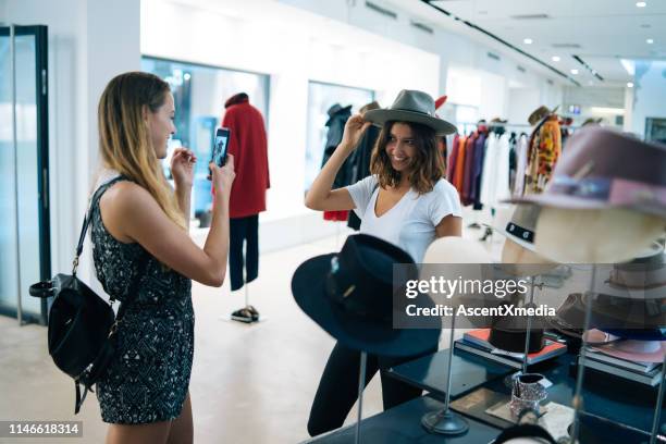 friends smile at each other while trying on outfits - generation z shopping stock pictures, royalty-free photos & images