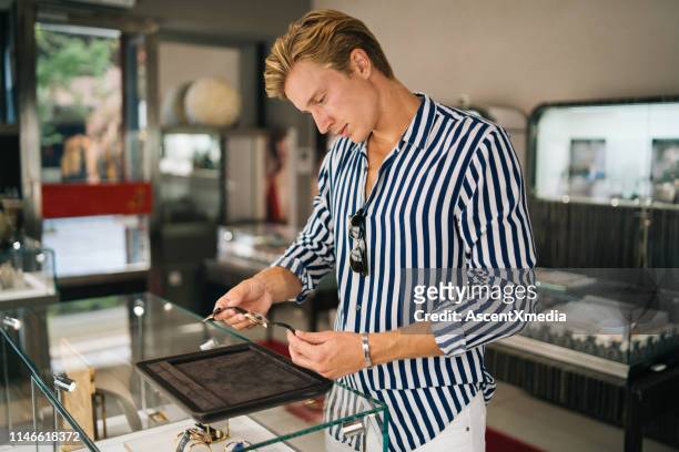 若い男は、時計の買物をしながら笑顔 - 高級時計 ストックフォトと画像