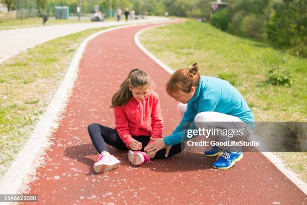 mother helping her daughter - twisted ankle stock pictures, royalty-free photos & images