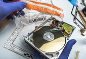 Police expert examines hard drive in search of evidence, conceptual image