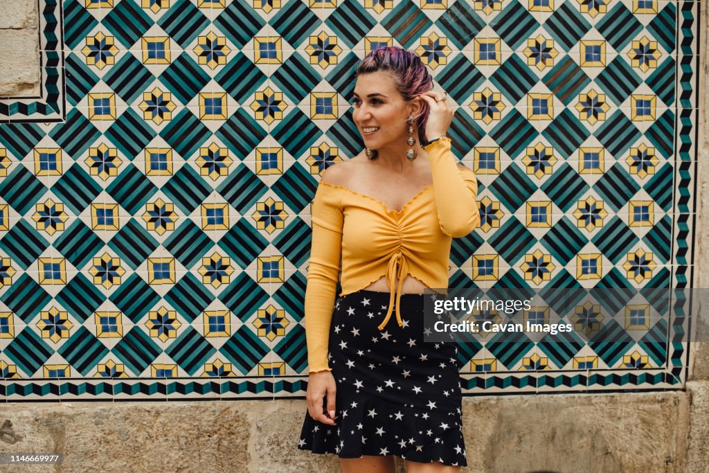 Young woman at the wall covered with portuguese tiles