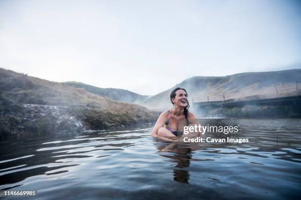 pretty woman lying on back in thermal water river. - river bathing imagens e fotografias de stock