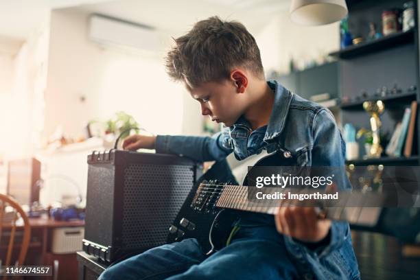 kleiner junge, der elektrische gitarre spielt - elektrogitarre stock-fotos und bilder