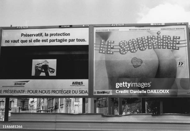 Affiche de sensibilisation pour le port du préservatif à côté de l'affiche du film 'Le Sourire' de Claude Miller, France.