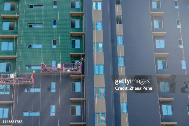 Workers are working on the exterior walls of a new apartment to be completed. From January to April of 2019, the investment in real estate...
