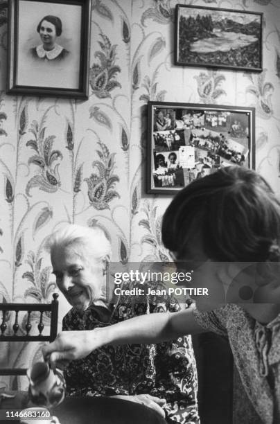 Femme âgée prenant le thé avec une aide à domicile, France.