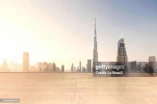 empty platform with city skyline and cityscape at sunset in dubai.uae - burj khalifa stock-fotos und bilder