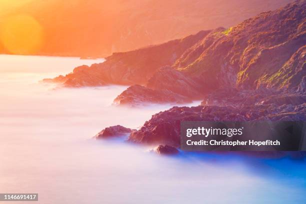 rocky coastline at sunset - littoral rocheux photos et images de collection