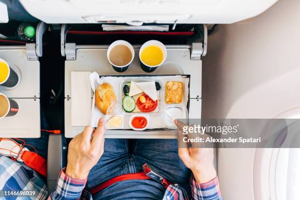 eating airplane food during a flight, personal perspective directly above view - airplane food stock-fotos und bilder