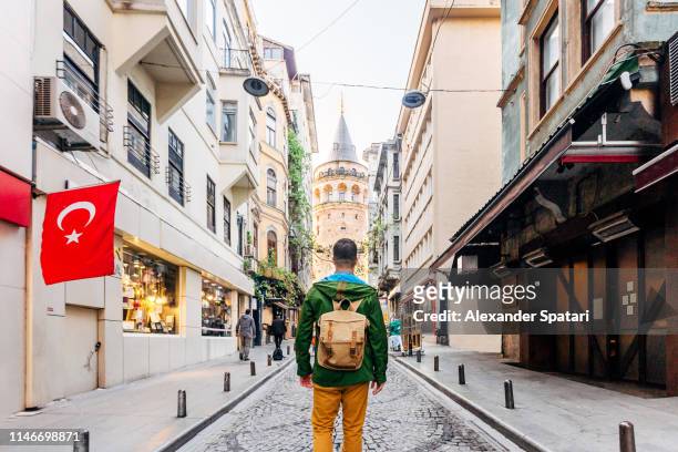 tourist with backpack looking at galata tower, istanbul, turkey - istanbul stock pictures, royalty-free photos & images