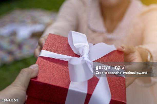 close-up of female hand holding a present - old man woman christmas stock pictures, royalty-free photos & images