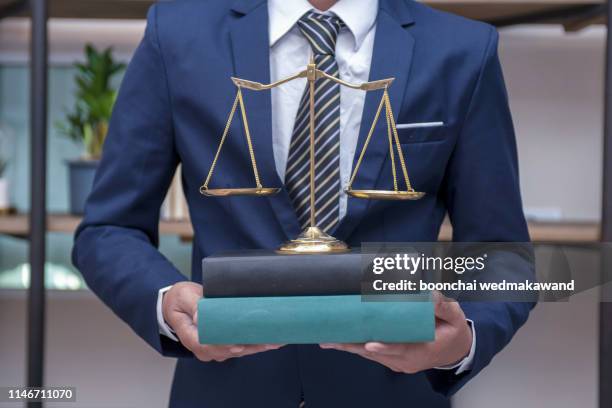 justice and law concept.male lawyer in the office with brass scale - tribunal stock pictures, royalty-free photos & images