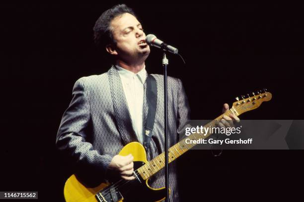 American Rock and Pop musician Billy Joel plays guitar as he performs onstage at Nassau Veterans Memorial Coliseum, Uniondale, New York, December 12,...