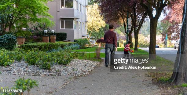pai e filho que andam na rua quieta da cidade em vancôver, bc, canadá. - center street elementary - fotografias e filmes do acervo