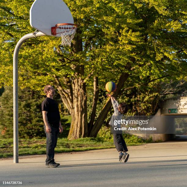 pai e seu filho dos anos de idade 7 que jogam o basquetebol no parque de stanley, vancôver, canadá - 6 7 years photos - fotografias e filmes do acervo