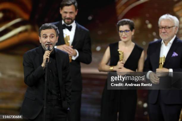 Talal Derki speaks on behalf of the team of the best documentary award winners on stage during the Lola - German Film Award show at Palais am...
