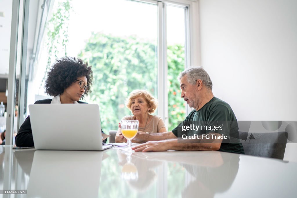 Helping Advisor Financial Advisor Helping A Senior Couple At Home High-Res Stock Photo ...