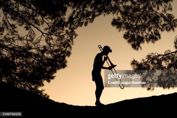 jeune femme jouant le trombone - trombone photos et images de collection