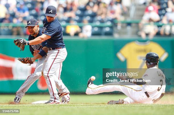 Alex Gonzalez and Dan Uggla of the Atlanta Braves collide when trying to both make a play at second base in front of Pedro Ciriaco of the Pittsburgh...