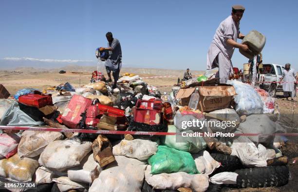 Afghan security official prepares to burning of confiscated illegal opium or raw heroine and alcoholic drinks in Nangarhar province, Afghanistan on...
