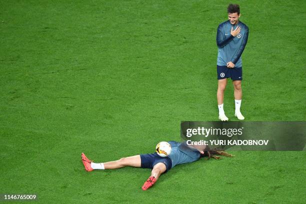 Chelsea's English-born Welsh midfielder Ethan Ampadu shares a laugh with Chelsea's Dutch midfielder Marco van Ginkel during a training session at the...
