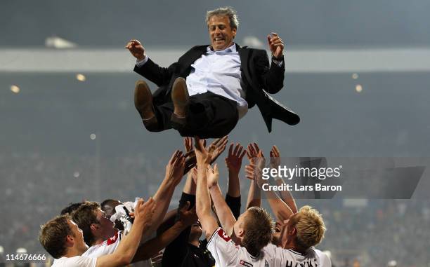 The players of Moenchengladbach throw head coach Lucien Favre up in the air after the Bundesliga play off second leg match between VfL Bochum and...