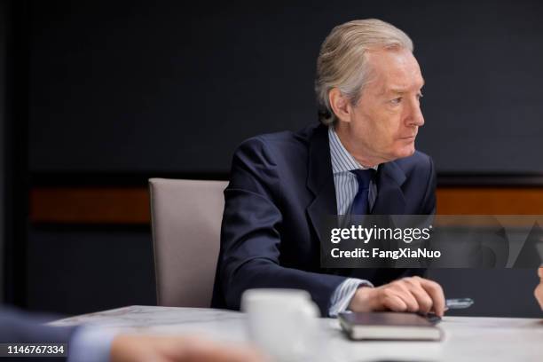 businessman listening to speaker in office meeting - shareholder stock pictures, royalty-free photos & images