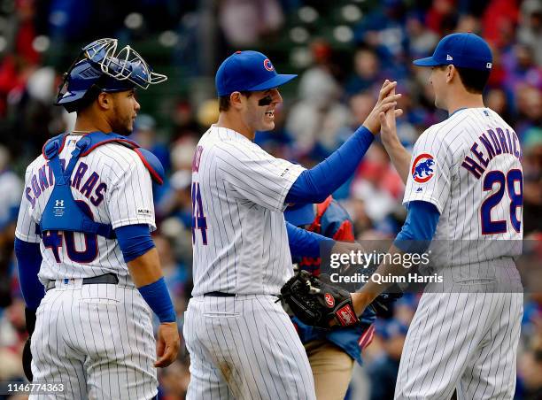 Willson Contreras, Anthony Rizzo and Kyle Hendricks of the Chicago Cubs celebrate the 4-0 win against the St. Louis Cardinals at Wrigley Field on May...