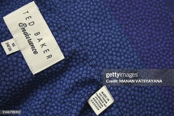 This photograph taken on May 24, 2019 shows a Ted Baker brand men's shirt labeled "Made in Vietnam" in a factory in Hanoi. - From socks and sneakers...