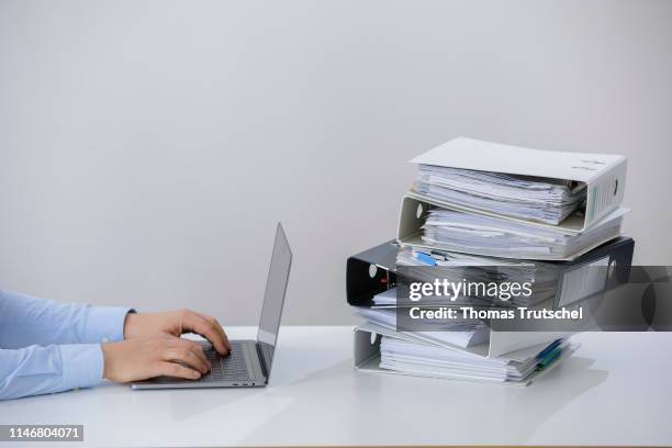 Symbolic photo on the subject of ' digitization in administration '. A computer is lying next to a pile of folders on May 29, 2019 in Berlin, Germany.