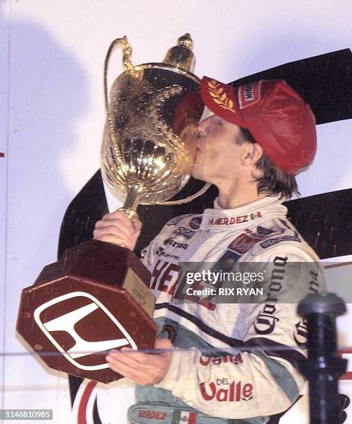 Mario Dominguez of Mexico kisses the Honda Indy 300 trophy after winning the race 27 October, 2002 in Gold Coast, Australia. Mario won the rain...