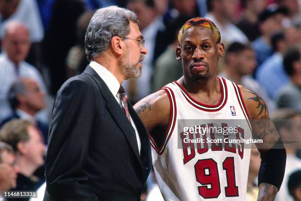 Head Coach Phil Jackson and Dennis Rodman of the Chicago Bulls talk during a game against the Charlotte Hornets during Game Five of the Eastern...