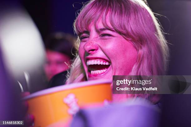cheerful woman enjoying at movie theater - dark humor stock pictures, royalty-free photos & images