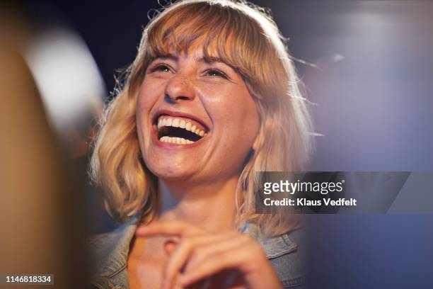 woman laughing during comedy movie - aufregung stock-fotos und bilder