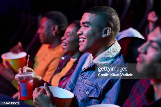 cheerful young friends enjoying movie in cinema hall - filme cómico - fotografias e filmes do acervo