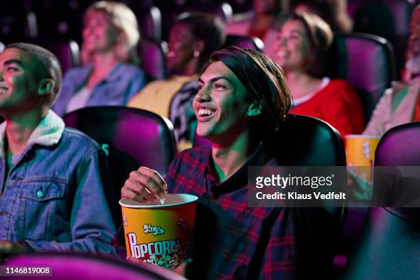 happy audience watching movie in cinema hall - filmindustrie stock-fotos und bilder